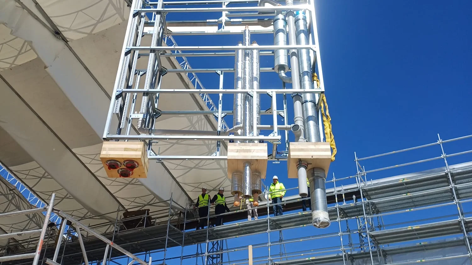 Vorgefertigtes Sanitärregister im Profilrahmen wird per Kran auf die Baustelle eingehoben